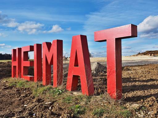 Heimat in großen roten Buchstaben in einem Neubaugebiet