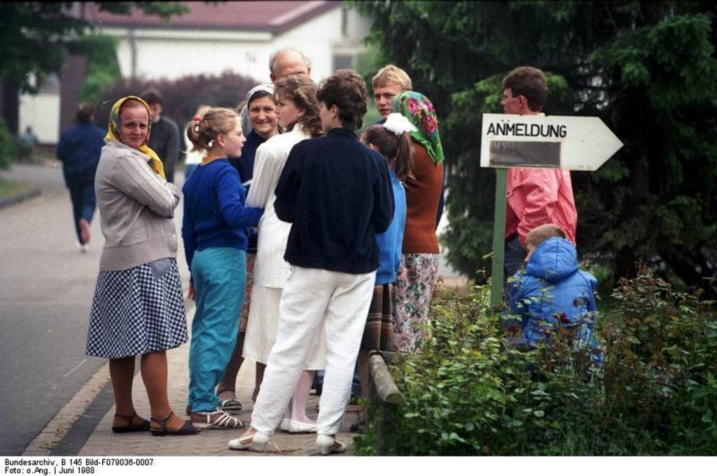 Grenzdurchgangslager Friedland.- Familie aus Tadschikistan neben Schild 