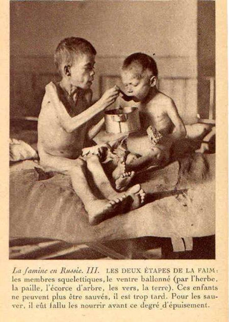 A postcard photograph (rotogravure) of two starving boys: one feeds the other. The boys are in an advanced stage of a famine related malnutrition. Their bellies are edematous due to ascites and liver failure resulting from severely inadequate protein intake. Their bodies have catabolized a large amount of skeletal muscle to compensate for the decreased protein intake, resulting in skeletal limbs. This is postcard number 3 of a set published by Rotogravure SA, Geneva, and sold by in 1922 to raise funds for the Ukrainian famine (number VIII of the set displayed bears the date 28 February 1922). The photographs were taken by Fridtjof Nansen and most likely published earlier as well in 1922 in his pamphlets and addresses for aid to the Russians.